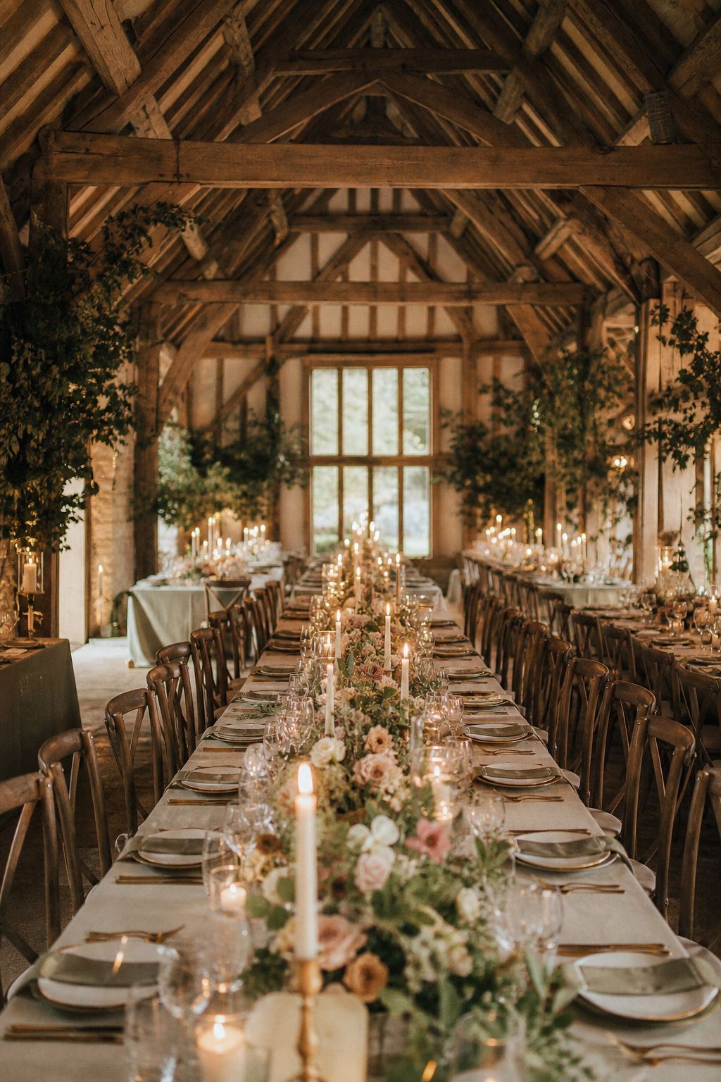 Candlelit long tables under the barn’s oak trusses